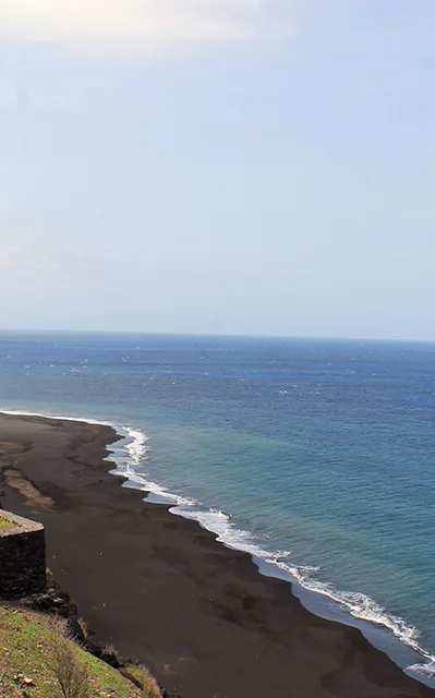 Black sand beach below the cliffs