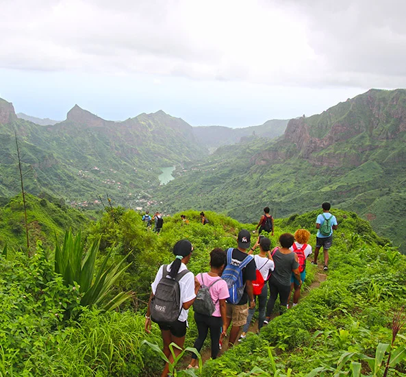 Group hiking above a green valley on Santiago Island